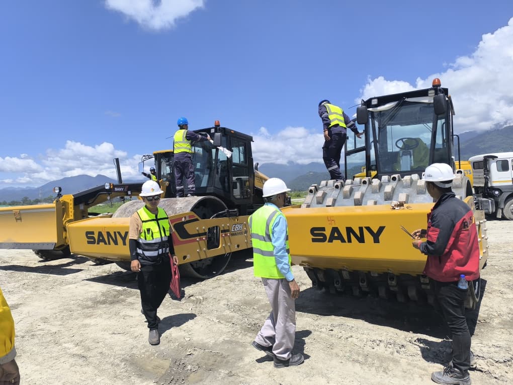 Participants and SANY padfoot rollers at the handover site